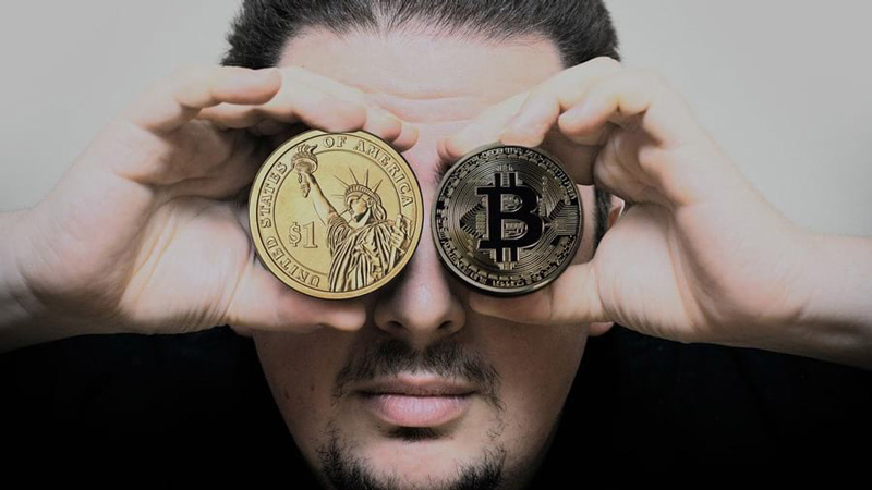 Man holding Bitcoin and US dollar coin – IRS cryptocurrency tax guidance