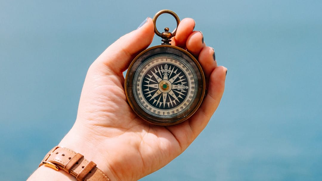 Guide to US Expat Taxes – hand holding vintage compass symbolizing direction in tax filing and compliance